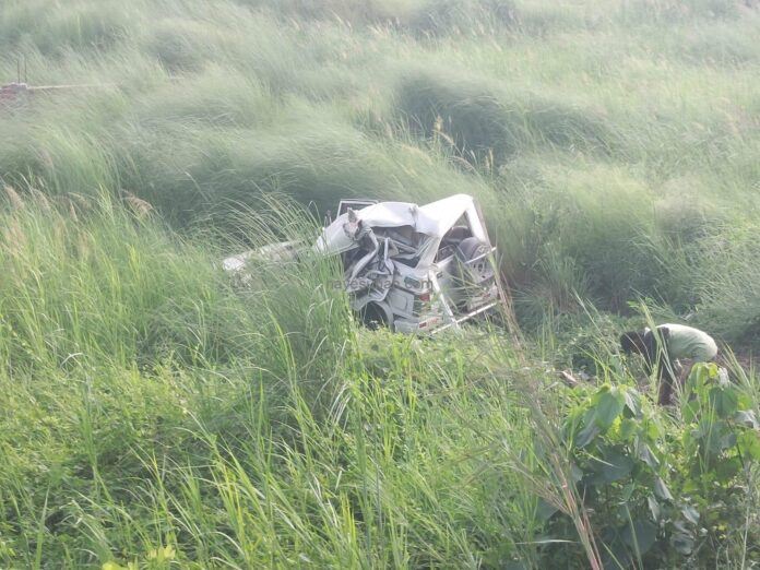 क्षतिग्रस्त और गड्ढे में पलटा वाहन।